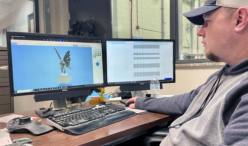 一位 MAMC 专家正在电脑上评估“天蛾人”雕像的 3D 模型。
