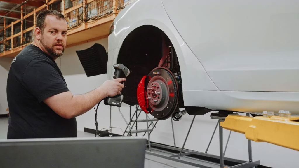 a man scans a Tesla car wheel with the HandySCAN 3D scanner
