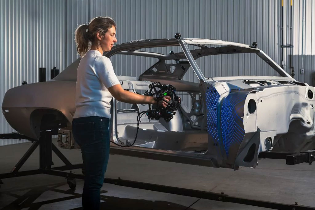 Engineer using the Creaform MetraSCAN BLACK+ to scan a car body with complex geometry and intricate areas