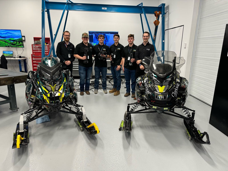 两辆雪地摩托后方站的是手持 Creaform 形创的三维 3D 扫描仪的 Clarkson University 清洁能源雪地摩托车团队成员。