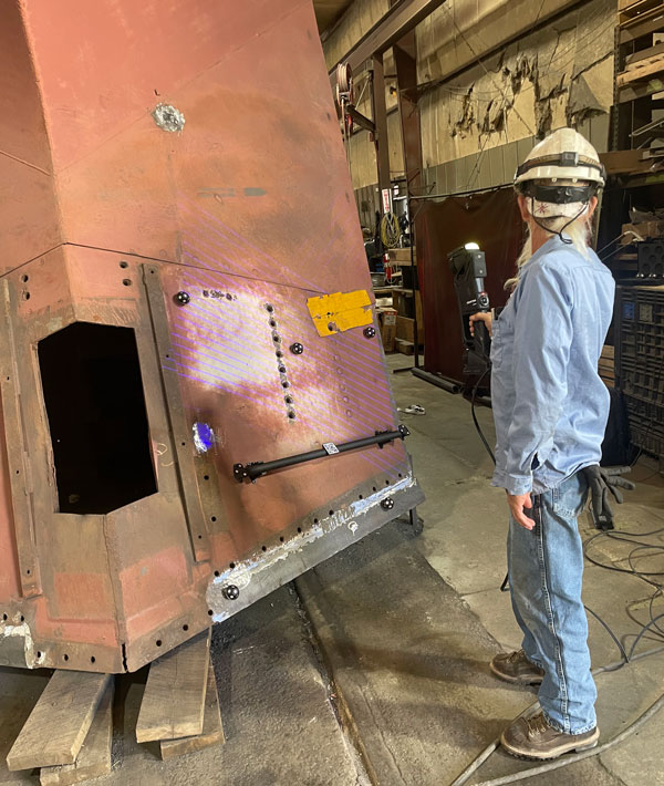 Mid-America Car 的一名操作人员使用大部件计量级三维扫描仪 HandySCAN 3D|MAX 系列计量级 3D 扫描仪对大型机车部件进行 3D 扫描。