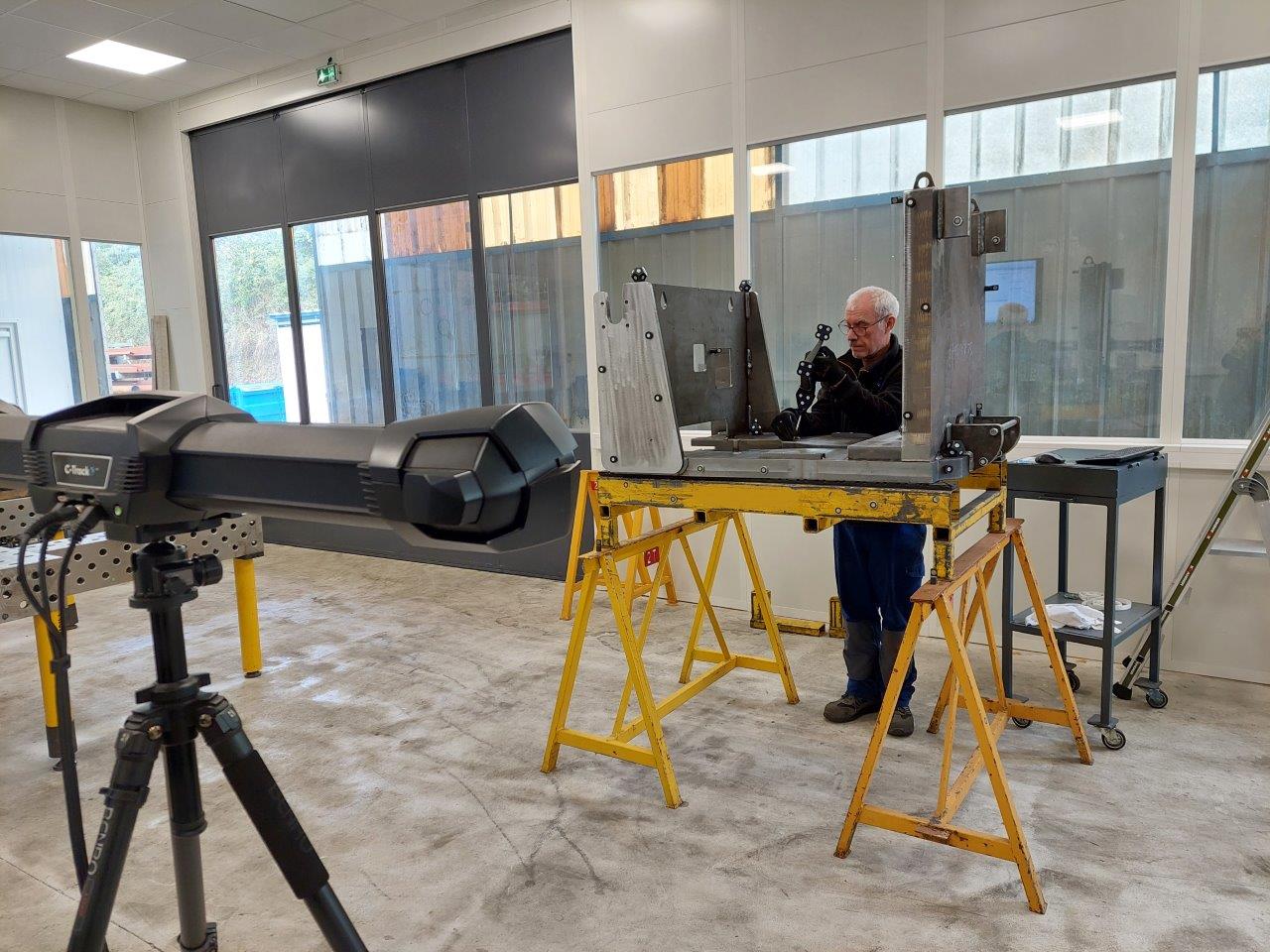 Un travailleur utilise le HandyPROBE pour prendre des mesures 3D d’un châssis soudé.