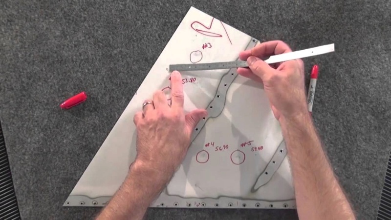 A picture of a technician using a manual method to assess aircraft damage.