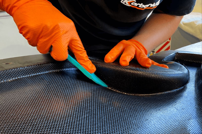A technician cuts a carbon-fiber part.