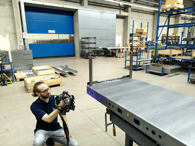 Ein Teammitglied der Brosius GmbH, das das tragbare Messsystem HandyPROBE an einem Metallbauteil verwendet.