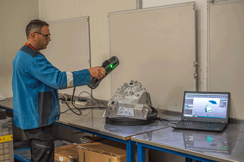 A GF Casting employee scans a casting with the Go!SCAN SPARK. The acquired data is displayed on the laptop in real time in the 3D metrology software