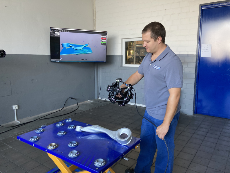 一名员工使用光学三坐标三维扫描仪 MetraSCAN 3D扫描金属部件