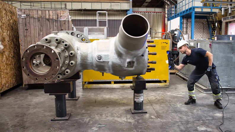 Empleado con casco de seguridad utilizando el escáner HandySCAN 3D|Serie MAX para medir un conector de tubería grande.