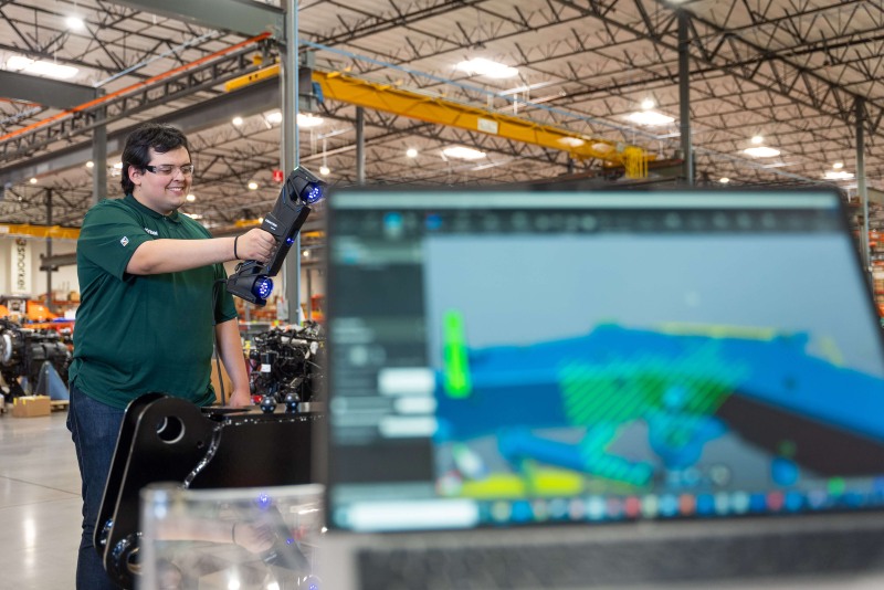 Técnico utilizando con entusiasmo la Serie MAX y la Creaform Metrology Suite para inspeccionar piezas grandes en un entorno de producción.