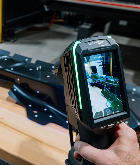 EVO Series 3D scanner scanning a sheet metal part, showing a color map pattern on the screen