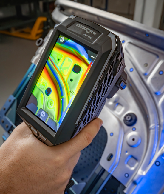EVO Series 3D scanner scanning a sheet metal part, showing a color map pattern on the screen