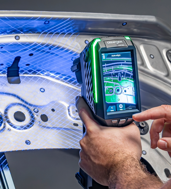 EVO Series 3D scanner projecting blue laser lines while scanning a contoured metal automotive part