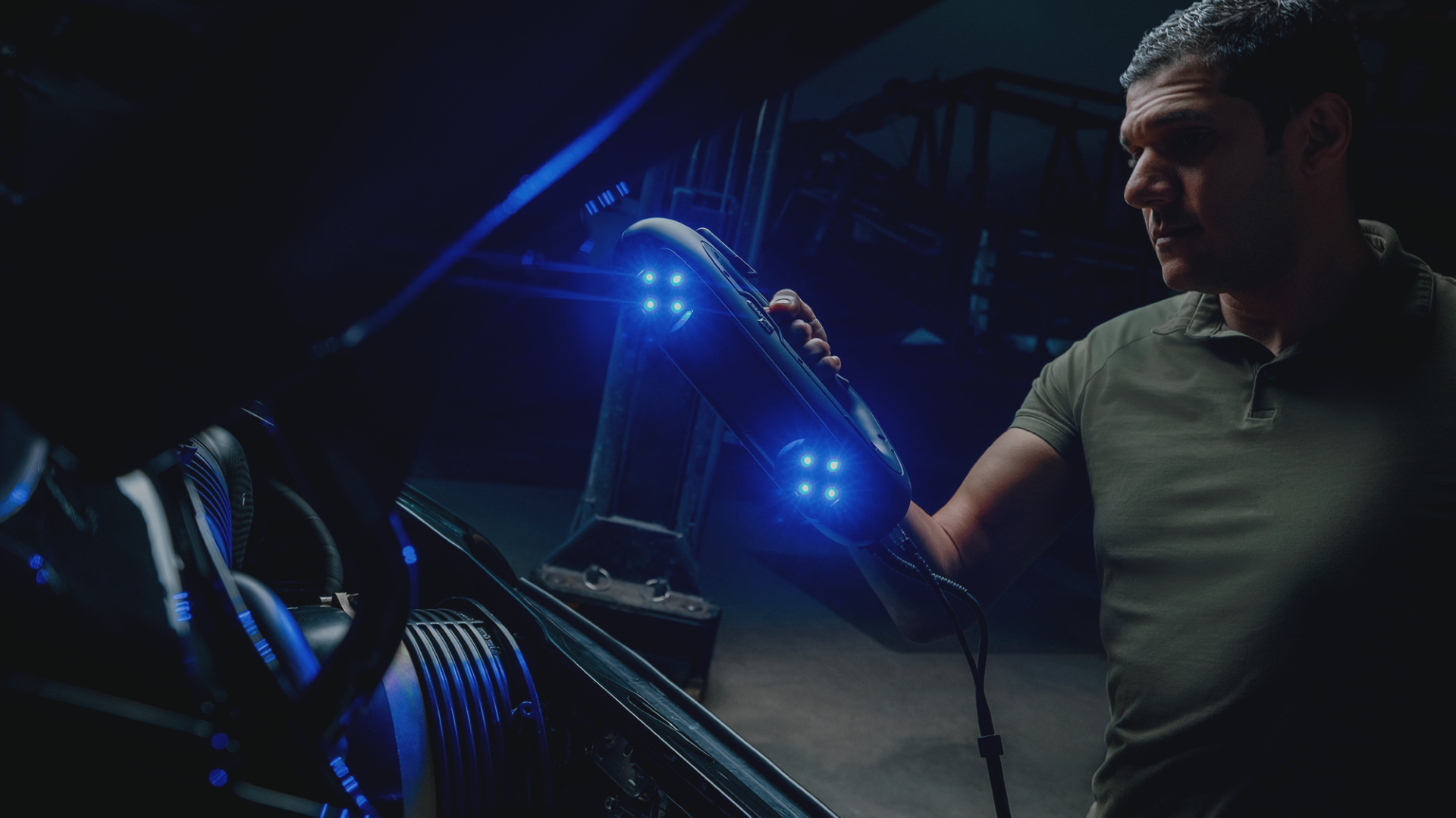 Expert using PRO Series 3D scanner with blue laser lights to scan an automotive part