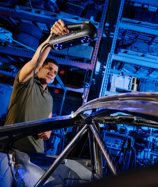 PRO Series 3D scanner with blue laser lines scanning the upper frame of a vehicle