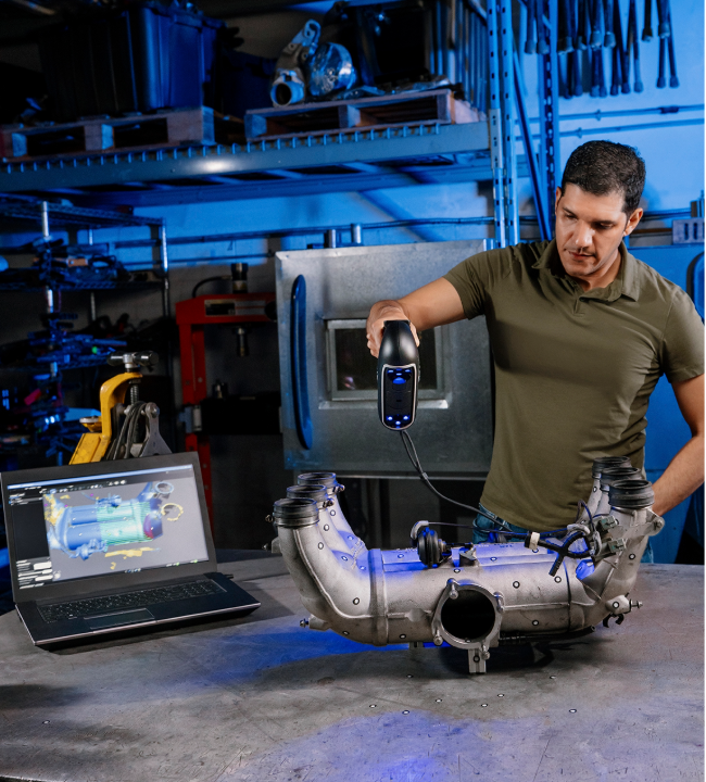 PRO Series 3D scanner capturing details of a metal automotive intake manifold next to a laptop