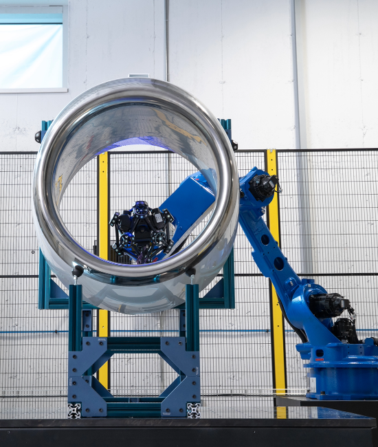 Blue robot holding a MetraSCAN 3D-R scanner inspection an aircraft inlet part
