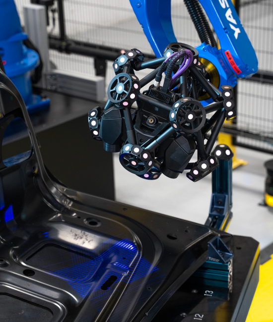 Blue robot with MetraSCAN 3D scanner inspecting a black automotive part with laser lines