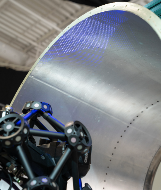 MetraSCAN 3D scanner inspecting a large metallic aircraft inlet surface with blue laser lines