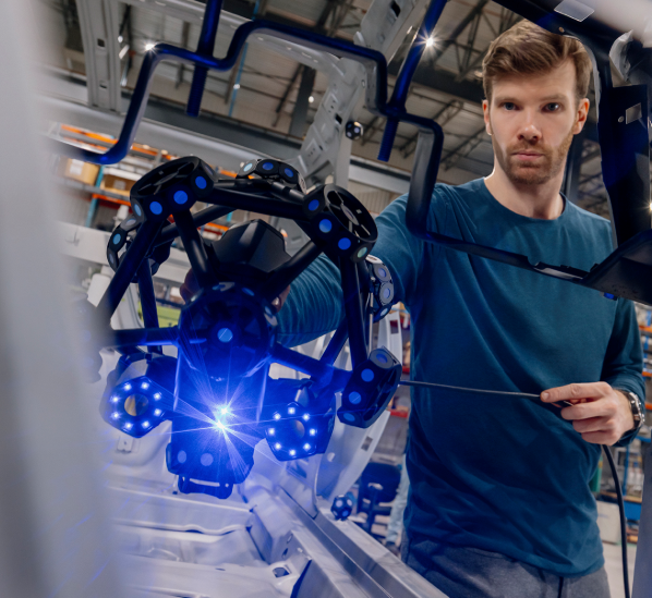 Technician in a manufacturing facility using a Creaform MetraSCAN 3D scanner to perform precise surface inspections on a large industrial mold.