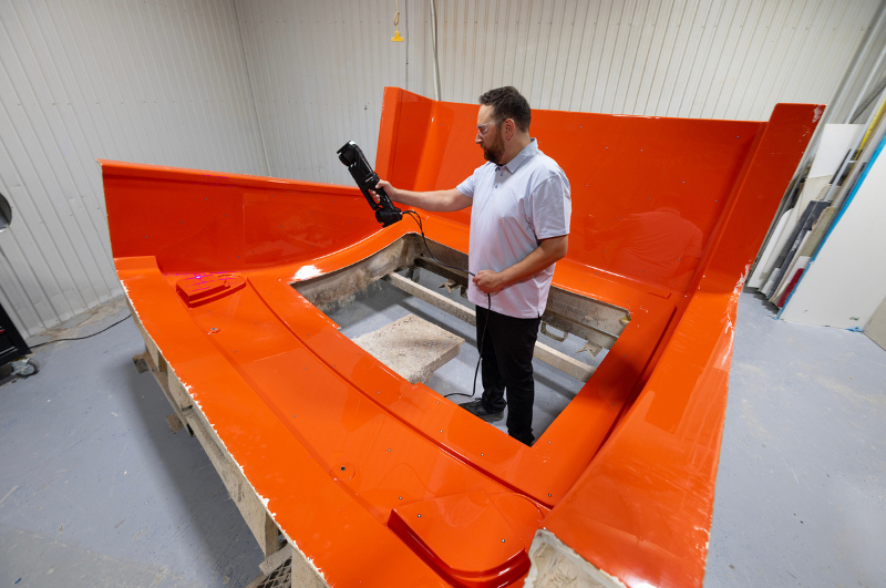 Technician scanning a large orange mold with the HandySCAN 3D MAX scanner