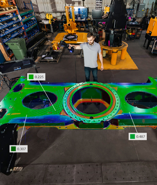 Technician scanning a large part we see a color map on the part