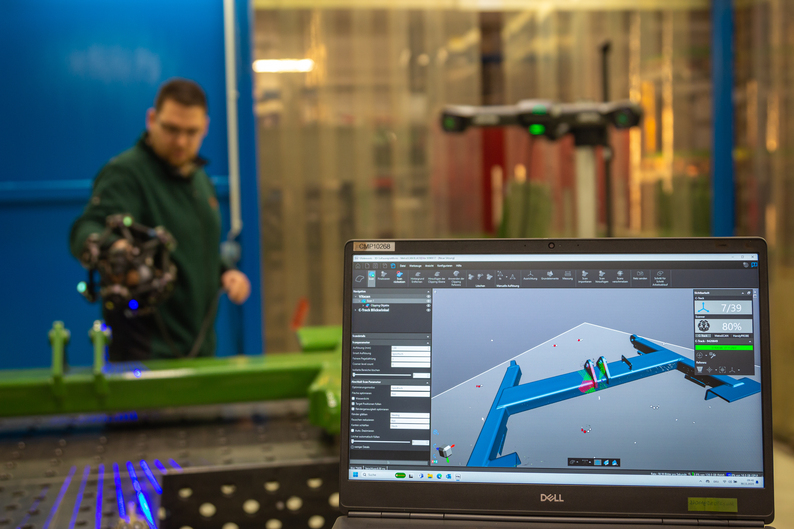 A detailed mesh of a large part appears in real-time on a computer screen while an engineer is scanning it with the MetraSCAN 3D.