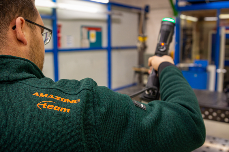 Un ingeniero que usa un suéter de Amazone está escaneando una pieza con escáneres 3D de grado de metrología de Creaform.