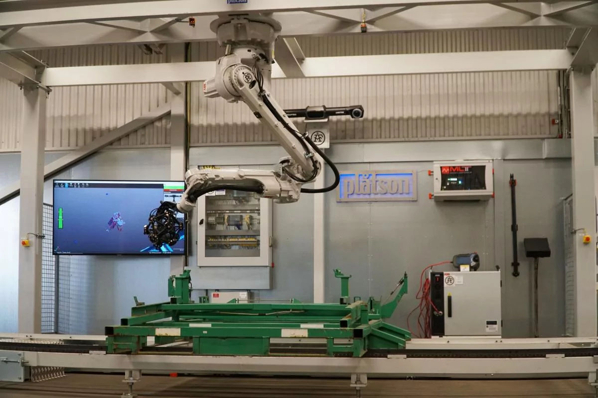 Wide view of two engineers inside a complex part of a nuclear tokamak part. 