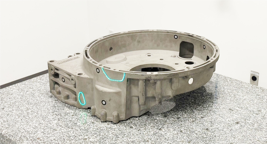 在工作台上铸造齿轮箱，在需要返工的部件上投射激光 