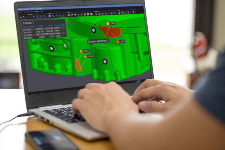 Dipendente al lavoro su un laptop che visualizza il pezzo nel modulo di ispezione della suite metrologica Creaform